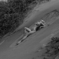 Fotografía boudoir artística en blanco y negro sobre dunas de arena en exteriores